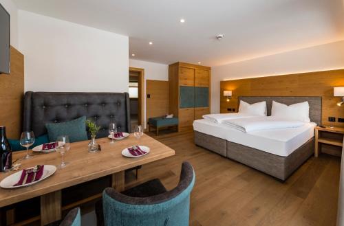 ein Hotelzimmer mit einem Bett und einem Esstisch in der Unterkunft Tiroler Weinstube in Seefeld in Tirol
