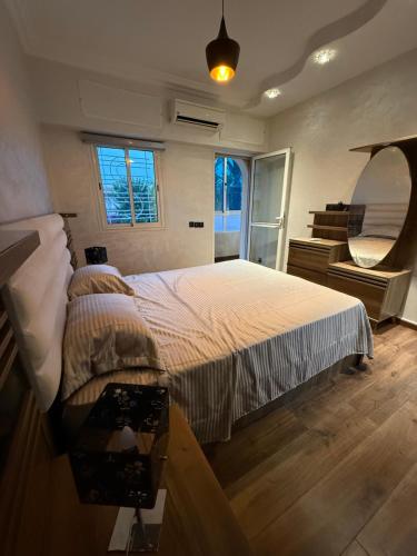 a bedroom with a large bed and a mirror at Pavillon corniche Bord de mer Proche Centre in Mohammedia