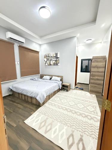 a bedroom with a large bed and a rug at Dar AL-HANAA in Nouakchott