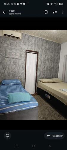 a picture of a bedroom with two beds and a door at Pousada Popular in Barreiras