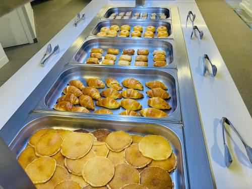 a buffet line with trays of pancakes and donuts at Hotel Susuqui in Sanxenxo