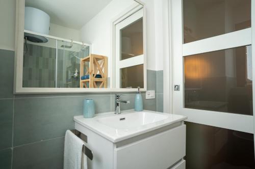 a bathroom with a white sink and a mirror at Minicasa Il Salone di Gino in Potenza