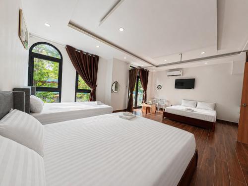 a large bedroom with two beds and a tv at Lam Stay Grand World Phu Quoc in Phú Quốc