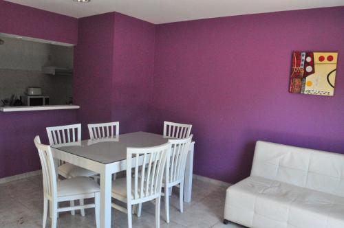a dining room with purple walls and a table and chairs at Los Abus in Colón