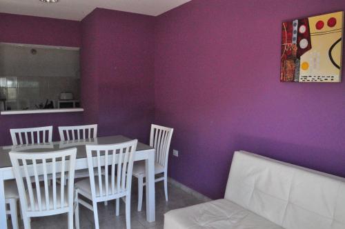 a dining room with purple walls and a table and chairs at Los Abus in Colón