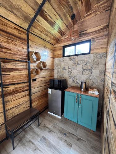 a kitchen with wooden walls and a stove in a room at Auka Boutique in Urubamba