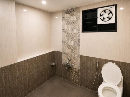 a bathroom with a toilet and a window at Hotel Tushar in Ahmedabad