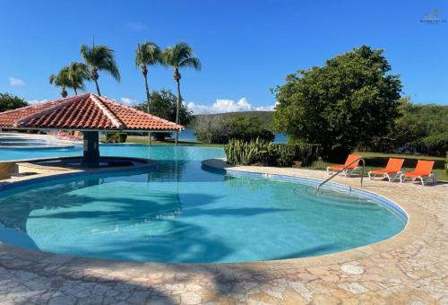 a swimming pool with a gazebo and palm trees at Seaside Villa Culebra in Culebra