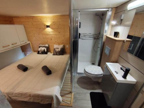 a small bedroom with a bed and a toilet at L'instant parental in Ustou