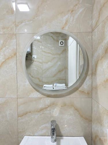 a bathroom with a sink and a mirror on a wall at Prime Rooms Tirana in Tirana
