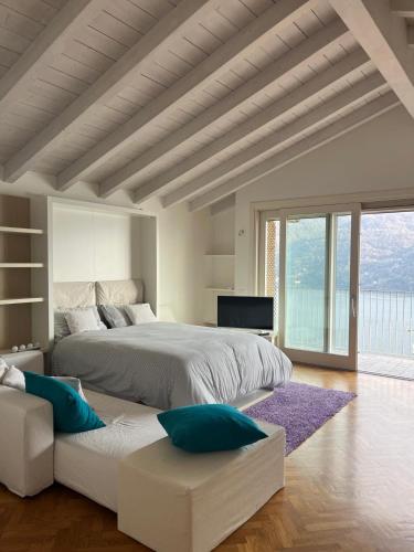a white bedroom with a large bed and a couch at Dream View Lake Como in Carate Urio