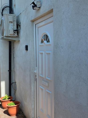 a door to a building with a window and plants at Corner Lodge in Eltham