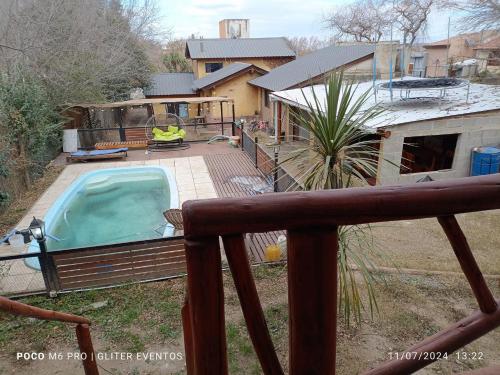 a backyard with a swimming pool and a house at Amphu colibri in La Falda