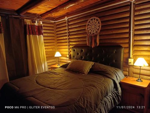 a bedroom with a bed in a room with wooden walls at Amphu colibri in La Falda