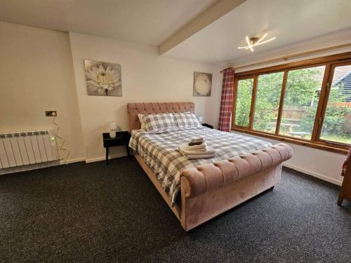 a bedroom with a large bed and a large window at Cottage - Sleeps 5 - Garden - River Side in Garve