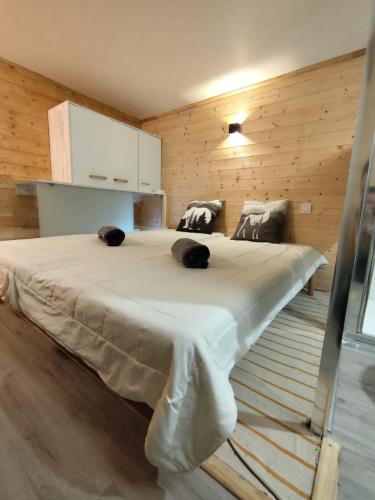 a large bed in a room with wooden walls at L'instant parental in Ustou