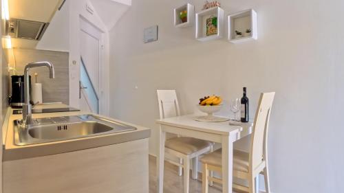 a small kitchen with a sink and a table at Villa Porto in Mlini