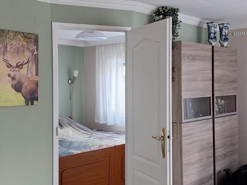a room with a bedroom with a bed and a door at Happy Place is een modern en comfortabel chalet met een grote afgesloten tuin op de Veluwe, Recreatiepark De oude Driest in Putten