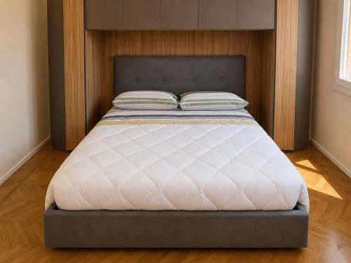 a large bed in a bedroom with a headboard at Attico Matteotti Sanremo Luxury Terrace Apartment in Sanremo