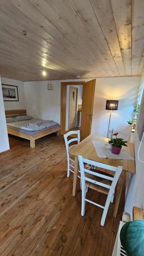 a room with a table and chairs and a bed at Ferienwohnung Dorfleben in Weiler-Simmerberg