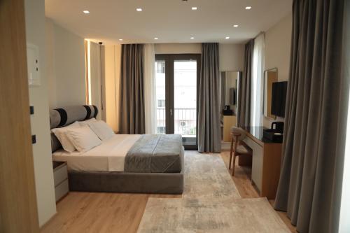 a hotel room with a bed and a television at Vila-L Hotel in Tirana