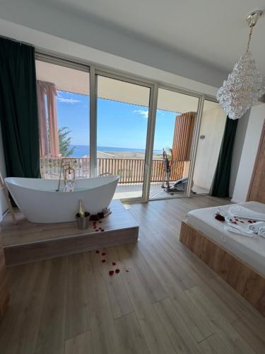 a bathroom with a tub with a view of the ocean at Villa Central Palms in Palasë