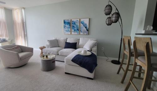 a living room with a white couch and chairs at Turnkey Tranquility with Marina & Intercoastal views in Lantana