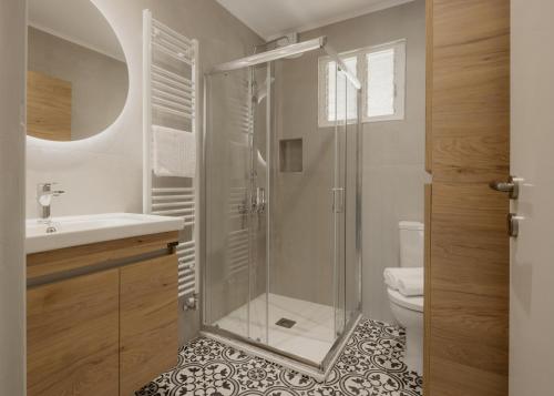 a bathroom with a glass shower and a toilet at Mediterranean Haven in Paleokastritsa