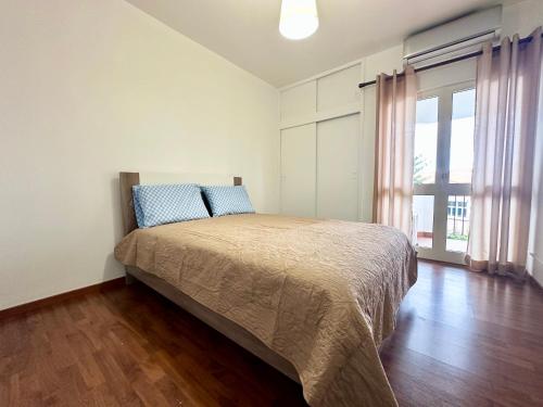 a bedroom with a bed and a large window at Teleferico Center Funchal in Funchal