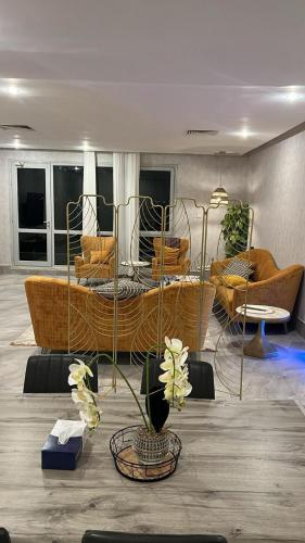 a living room with chairs and a table with flowers at Luxury B3 Chalet COMO in Al Khīrān