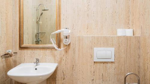 a bathroom with a sink and a mirror at MAX International Hotel in Râşnov
