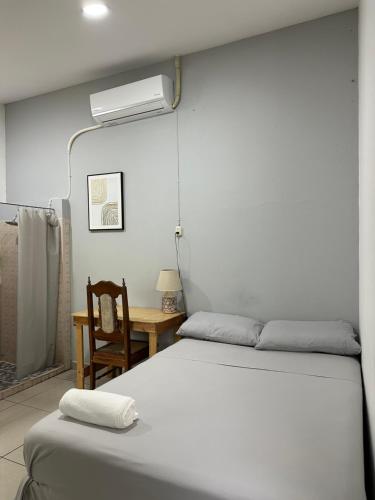 a bedroom with two beds and a desk with a fan at Hostal El Amate #1 in Suchitoto
