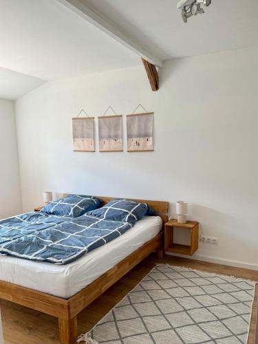 a bedroom with a bed with a blue comforter at Ferienwohnung 'kommodig' nahe der Eider in Delve
