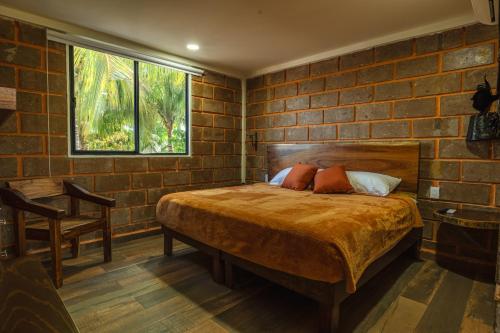 ein Schlafzimmer mit einem Bett und einer Ziegelwand in der Unterkunft Hotel Jabal Inn in Tixmucuy