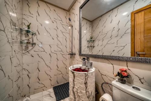 a bathroom with a toilet and a mirror at Prime location Moroccan-Style Luxury Apartment with Parking near Carré Eden Shopping Center in Marrakesh