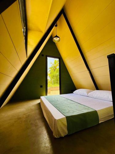 a bedroom with a large bed in a yellow room at Hideout Boomeru in Matale