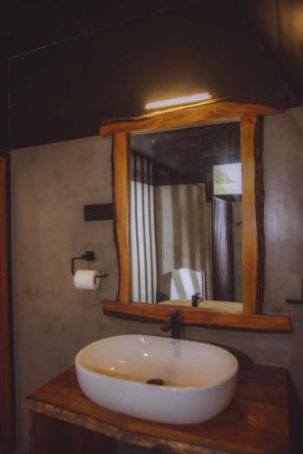 a bathroom with a white sink and a mirror at Hideout Boomeru in Matale