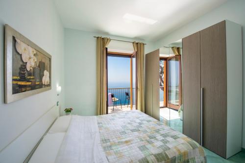 a bedroom with a bed with a view of the ocean at Calipso Residence in Furore