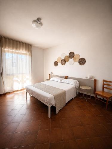 una camera da letto con un letto, un tavolo e una finestra di Hotel Mistral ad Alghero