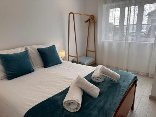 a bedroom with a bed with towels on it at Casa Maria Olímpia in Nazaré