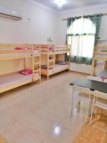 a room with bunk beds and a table and chairs at Home Line in Doha