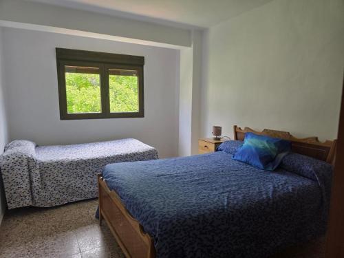 a bedroom with two beds and a window at Casa Bajo Castillo in Montán