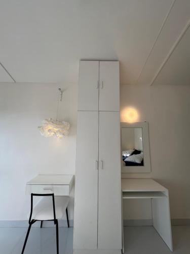 a white room with a desk and a white cabinet at THHPSOCIETY - Taha Cottages in Bhīm Tāl
