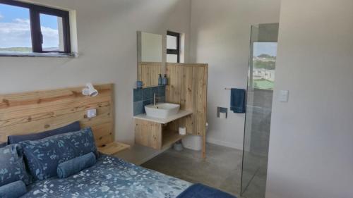 a bedroom with a bed and a sink and a shower at Seals Tides - sleeps 12 in Cape St Francis