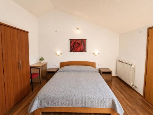 a bedroom with a bed and a painting on the wall at Apartments Izabela Mužić-Fornarić Cres in Cres