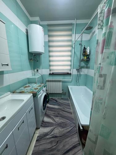 a bathroom with a washing machine and a sink at Starpath Homestay in At-Bashy
