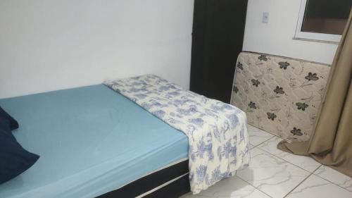 a blue bed with a blanket on it in a room at Ap cobertura próx Vila Militar, Afonsos e CEFAP in Rio de Janeiro