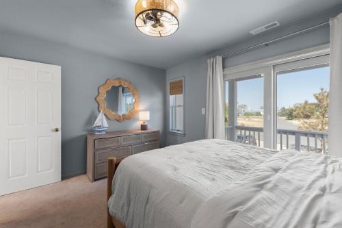 a bedroom with a bed and a large window at Dune Deck in Corolla