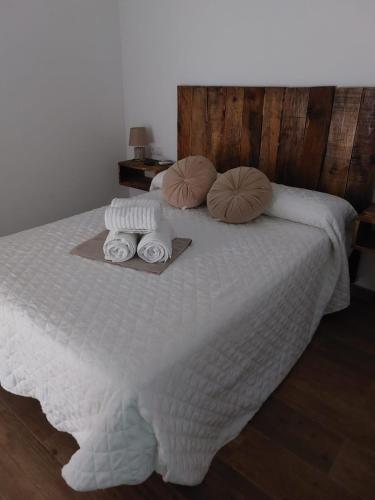 a white bed with towels and pillows on it at Apartamentos vacacionales malba Bajo A in Punta Umbría