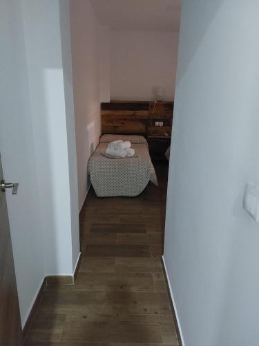 a small room with a bed and a wooden floor at Apartamentos vacacionales malba Bajo A in Punta Umbría